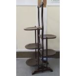 A 1930s mahogany folding cakestand with five staggered demi-lune shelves, on a played plinth  41"h