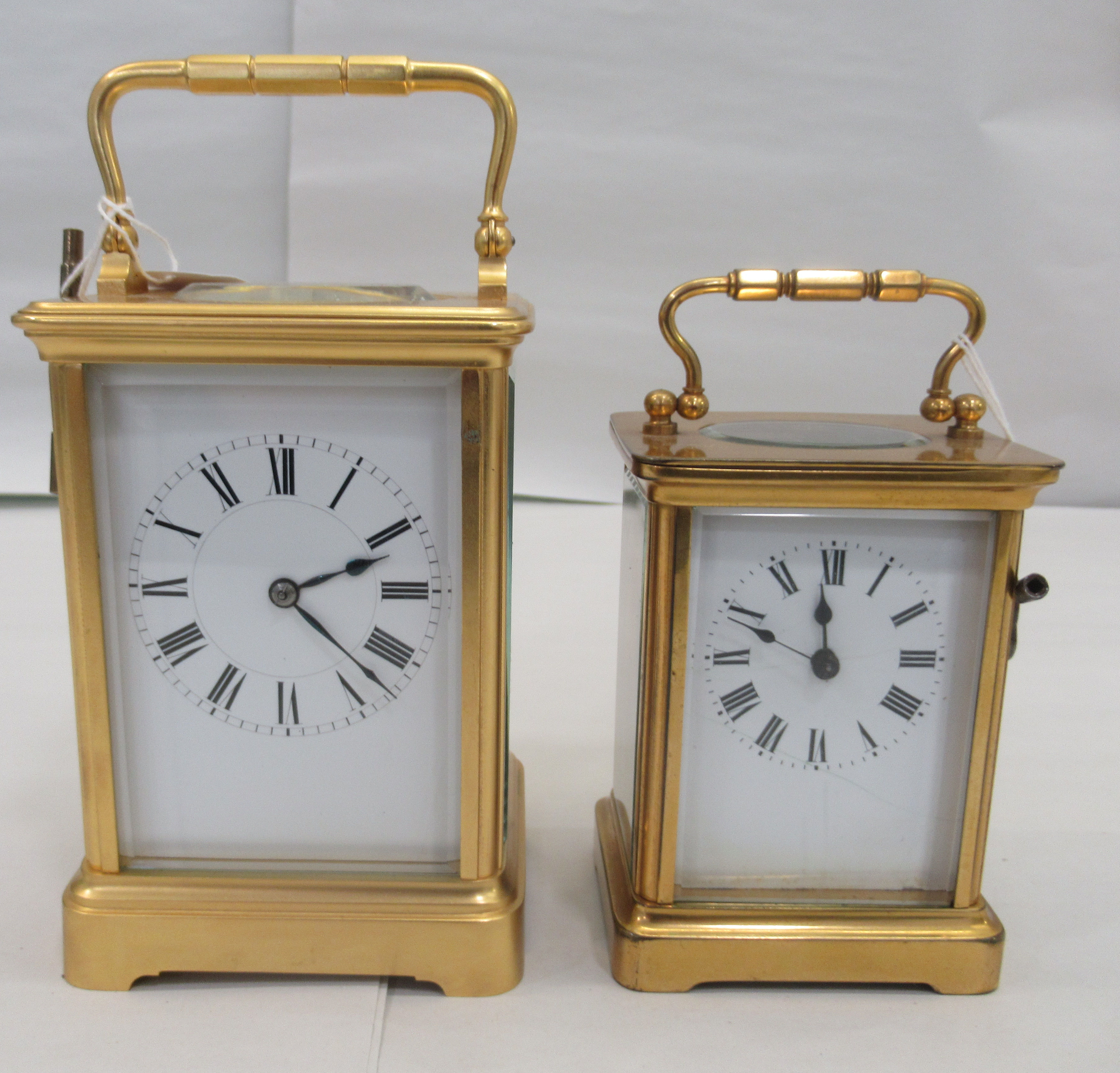 Two similar 20thC brass cased carriage timepieces with bevelled glass panels and folding top