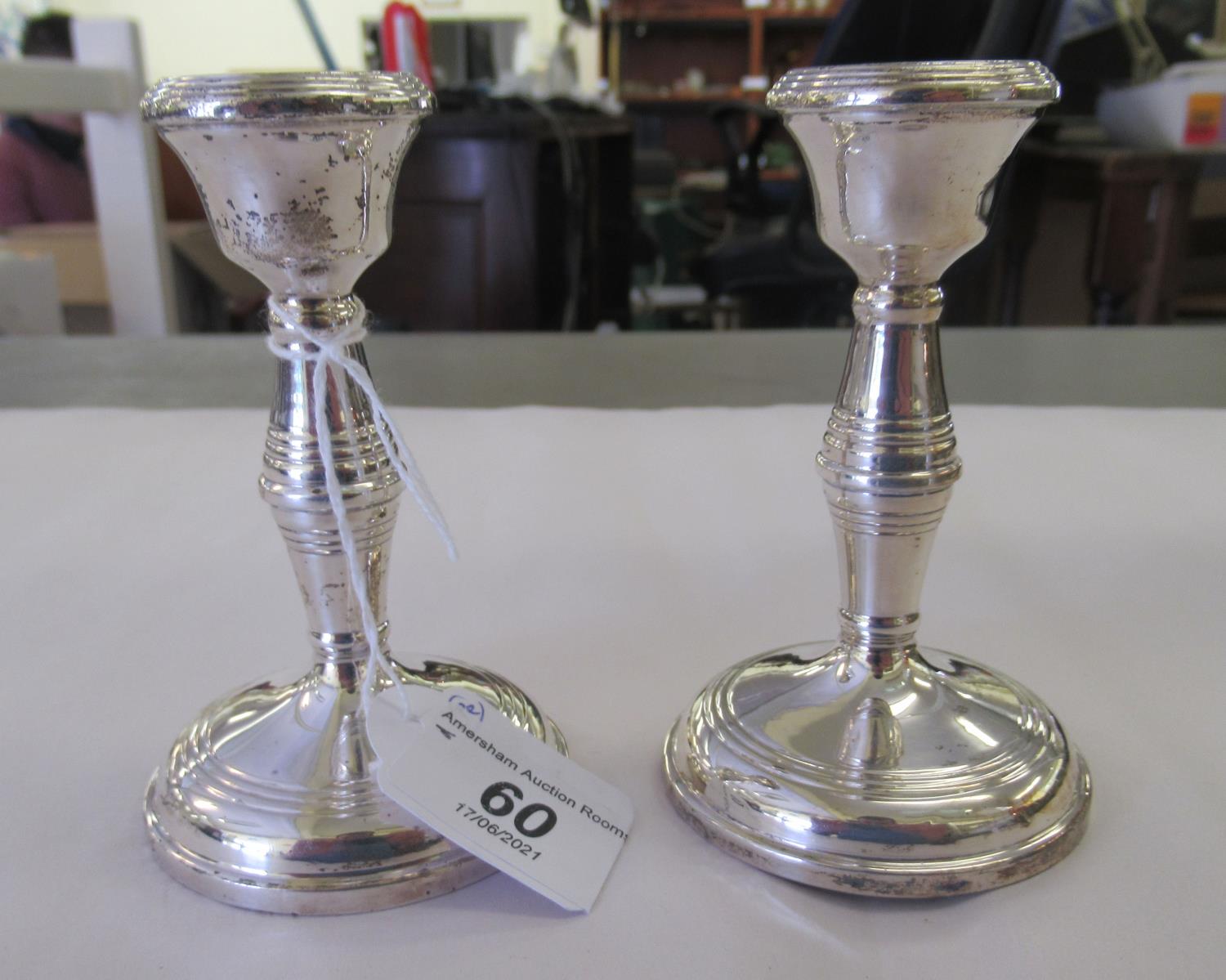 A pair of loaded silver candlesticks with integral sockets and baluster stems  Birmingham 1963  4.
