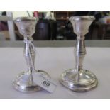 A pair of loaded silver candlesticks with integral sockets and baluster stems  Birmingham 1963  4.