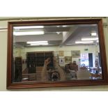 A modern mirror, the bevelled plate set in a mahogany effect frame  22" x 34"