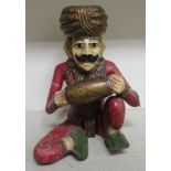 A 20thC painted and carved wooden figure, a Kasack man playing a drum  12"h