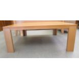 A modern light oak finished coffee table, raised on planked legs  16"h  39"w