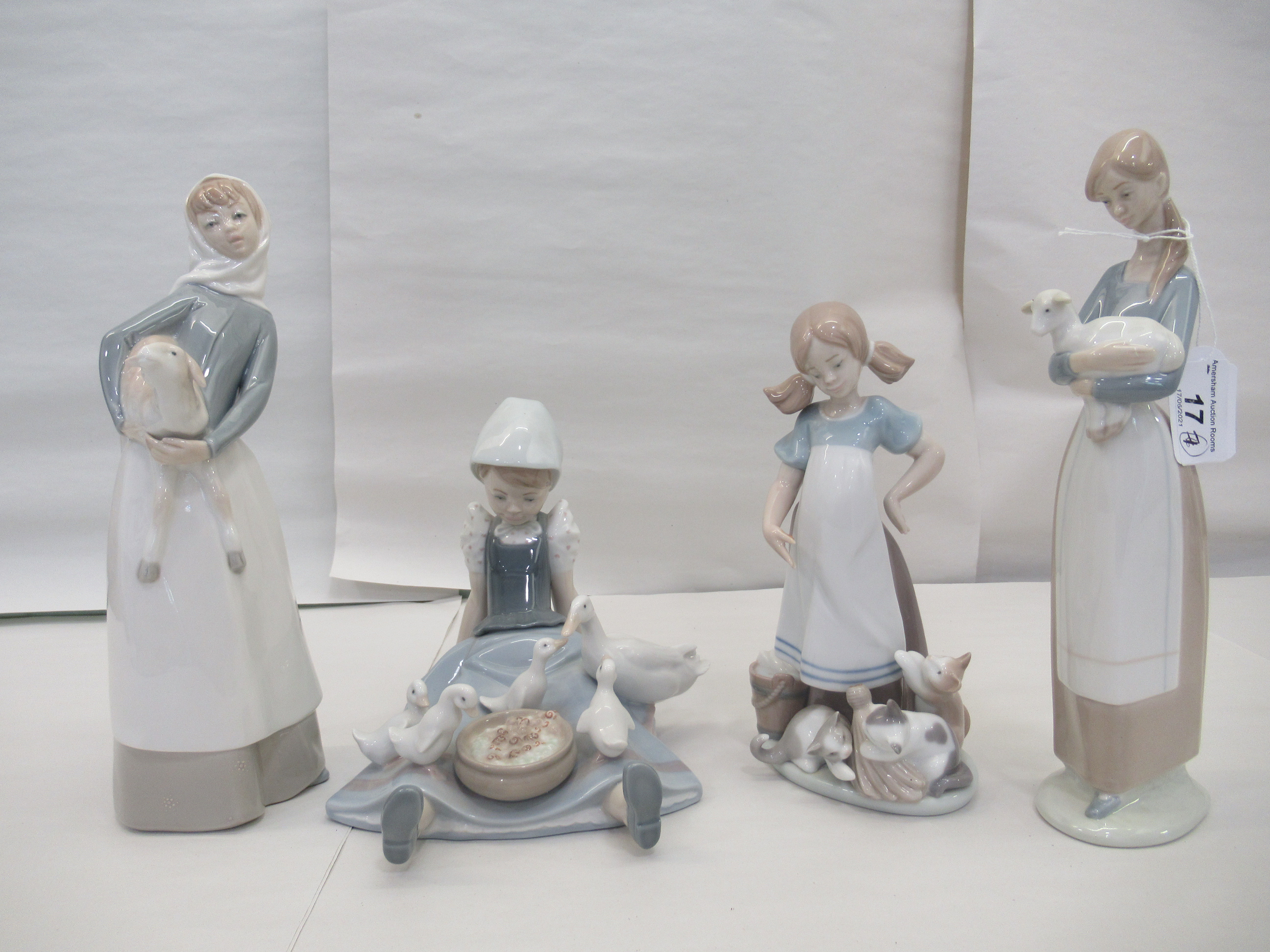 Seven Lladro porcelain figures: to include a young woman, carrying a lamb  11"h - Image 2 of 5