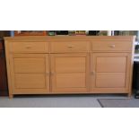 A modern Continental panelled, light oak sideboard with round corners, comprising three inline