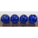A set of four clear and dark blue coloured glass paperweights with interior bubble ornament  6"h