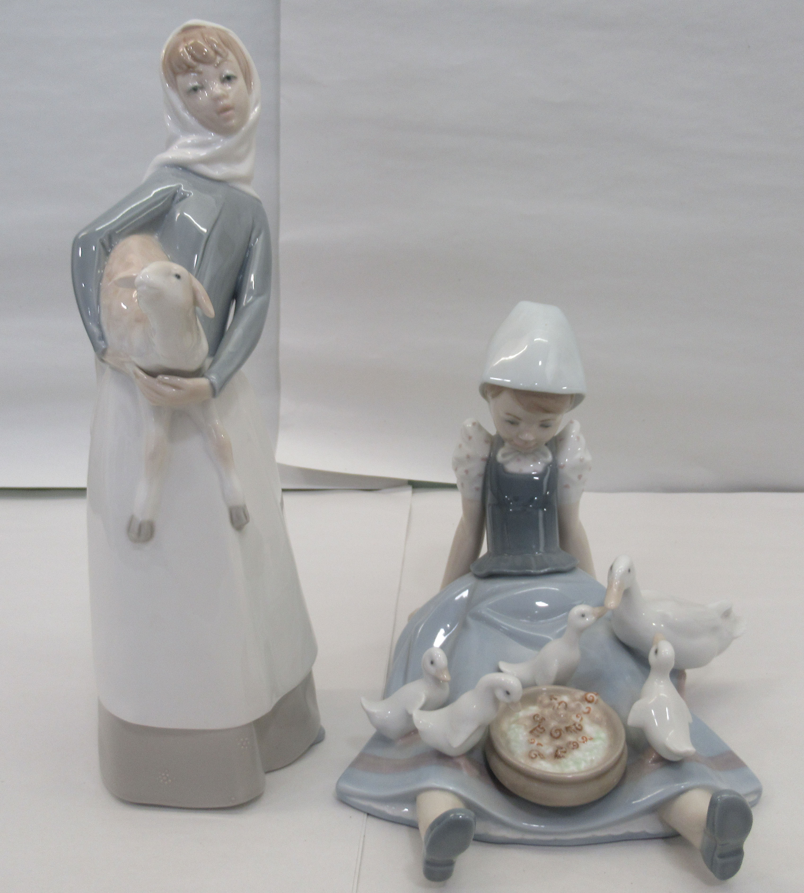 Seven Lladro porcelain figures: to include a young woman, carrying a lamb  11"h - Image 3 of 5