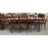 A 1960/70s rosewood finished extending dining table with folding central leaves, raised on square,