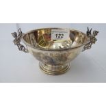 A silver bowl with an applied wire rim and opposing sphinx style handles, on a pedestal footrim