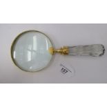 A magnifying glass, in a lacquered brass frame, on a facet cut glass handle