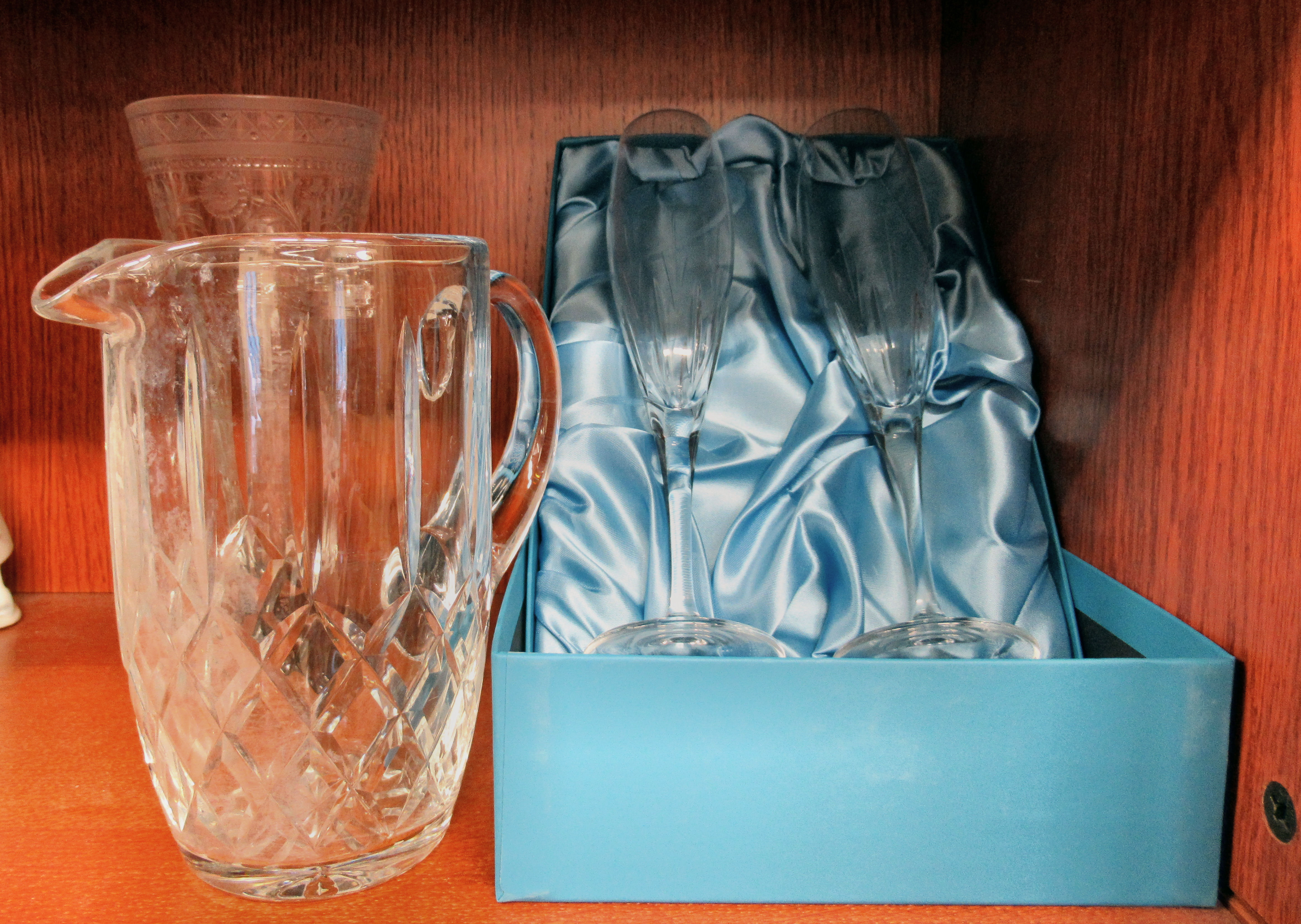 A trumpet shaped clear glass vase, on a black glass pedestal foot, wheel engraved and cut with