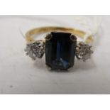 An 18ct gold and platinum ring, set with a central sapphire, flanked by two diamonds