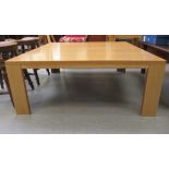 A modern light oak finished coffee table, raised on planked legs  16"h  39"w