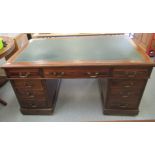 An early 20thC mahogany desk, the top set with a tooled green hide scriber and three frieze drawers,