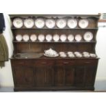 A mid 20thC panelled oak dresser, the superstructure comprising open shelves, on a four drawer/