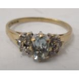 A 9ct gold ring, set with a central aquamarine, flanked by small diamonds