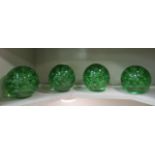 A set of four green glass doorstop with internal bubble decoration  5.5"h