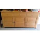 A modern Continental panelled, light oak sideboard with round corners, comprising three inline