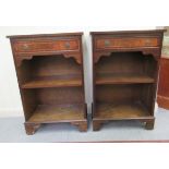 A pair of modern mahogany finished bedside cupboards, each containing a drawer, over open shelves,