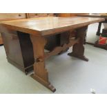 A 20thC oak dining table, raised on pegged trestle ends and platform feet  30"h  55"w