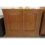 A modern waxed pine low side cupboard with a pair of panelled doors, on a plinth  28"h  36"w