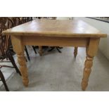 A 20thC bleached pine farmhouse kitchen table, the top raised on ring turned, tapered and block legs