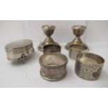 Silver collectables, viz. a ring box; a pair of dwarf candlesticks; and four napkin rings  mixed