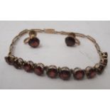 A suite of yellow metal jewellery set with faceted garnets, viz. a bracelet and a matching pair of