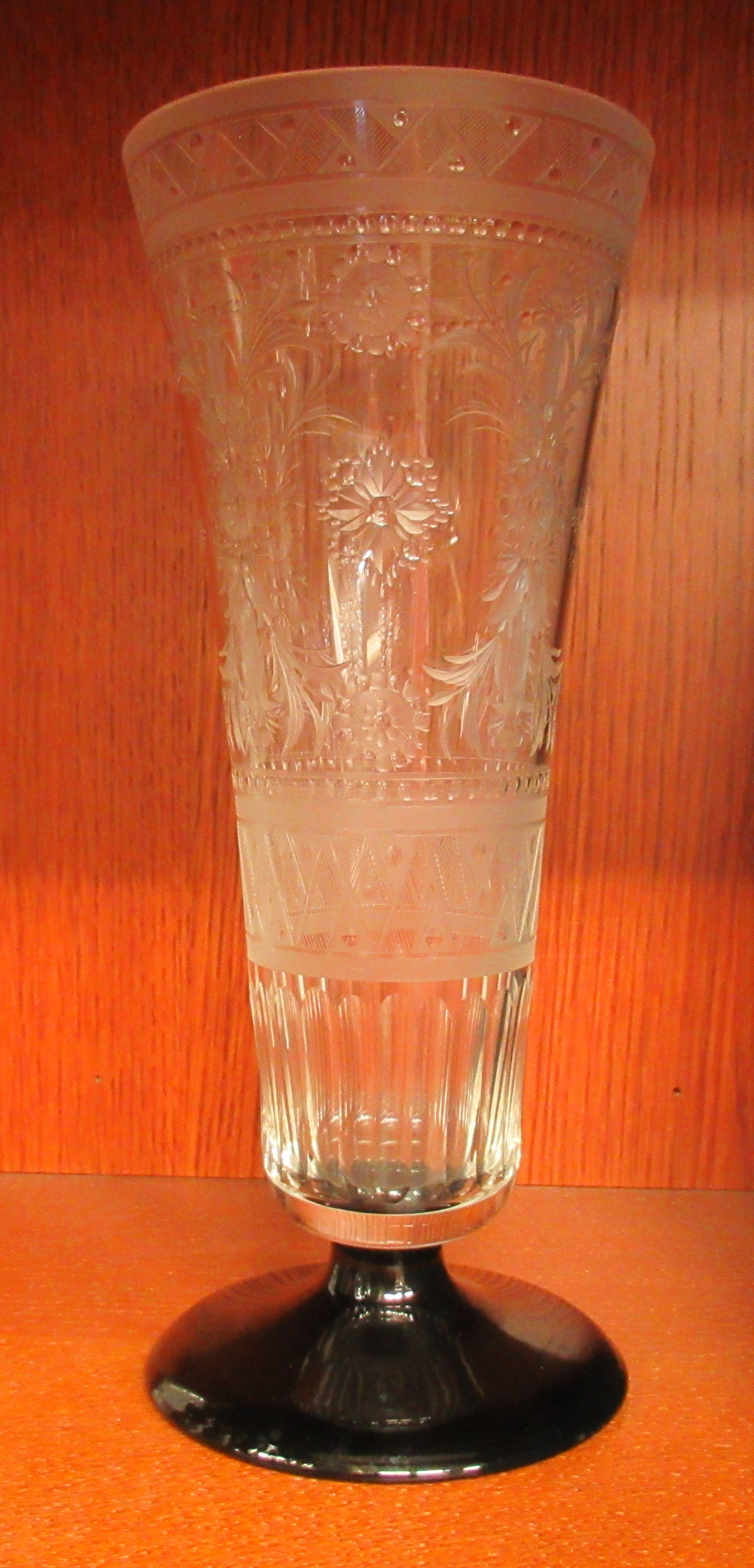 A trumpet shaped clear glass vase, on a black glass pedestal foot, wheel engraved and cut with - Image 2 of 3