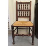 A 19thC Lancashire oak framed side chair with a spindled back and a woven rush seat, raised on