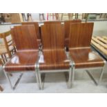 A set of six vintage design dining chairs, the shaped teak seat raised on a chromium plated, splayed