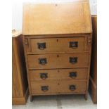 An early 20thC light oak lady's bureau, the fall flap over four drawers, raised on planked ends
