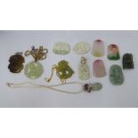 Twelve Oriental jade style pendants, carved with dragons and cloud motifs