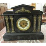 A 1930s black slate cased mantle clock of architectural form; faced by an Arabic dial, on a