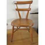 A child's mid 20thC Ercol beech and elm framed chair, the solid seat raised on elliptically turned