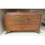 A Regency brass inlaid rosewood tea casket of sarcophagus form with ring handles, the hinged lid