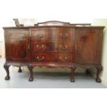 A 1920s mahogany sideboard with an arrangement of three drawers/two panelled doors, raised on