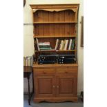 A modern pine dresser, the superstructure with three open shelves, over two drawers and two panelled