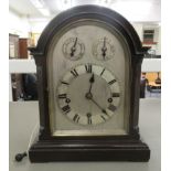 An Edwardian mahogany cased bracket clock with a round arched top and straight sides, on a plinth