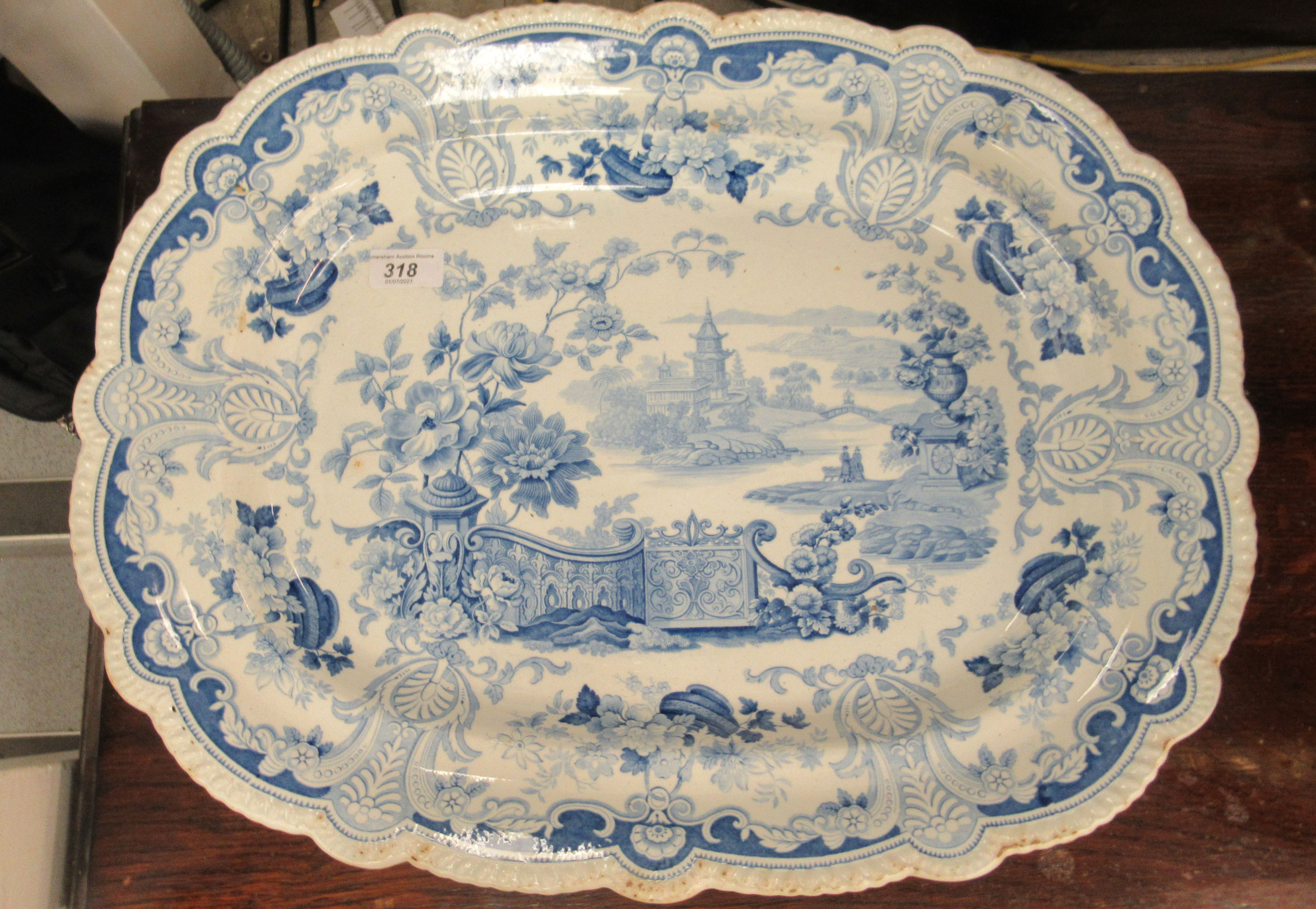 A 19thC earthenware meat plate, having a raised wide, wavy edged border, decorated in blue and white