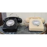 Two vintage style dial type telephone handsets, one in a cream coloured case, the other black