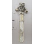 A baby's silver coloured metal rattle with a mother-of-pearl teether