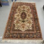 A Persian rug, decorated with floral designs, on a cream and multi-coloured ground  45" x 72"