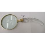 A magnifying glass, in a lacquered brass frame, on a facet cut crystal handle