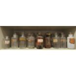 A collection of late 19th/early 20thC clear glass apothecary jars, some with branded labels and