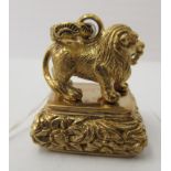 A gilt metal pendant seal, cast as a standing lion