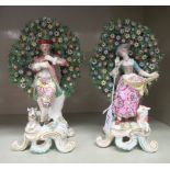 A pair of mid 19thC Derby porcelain bocages, a man playing a flute beside a dog and a woman