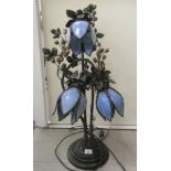 A cast metal table lamp of organic design with three tulip design blue glass shades  30"h