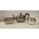 A three piece silver tea set of elongated, bulbous, panelled form with incurved corners, on bun feet