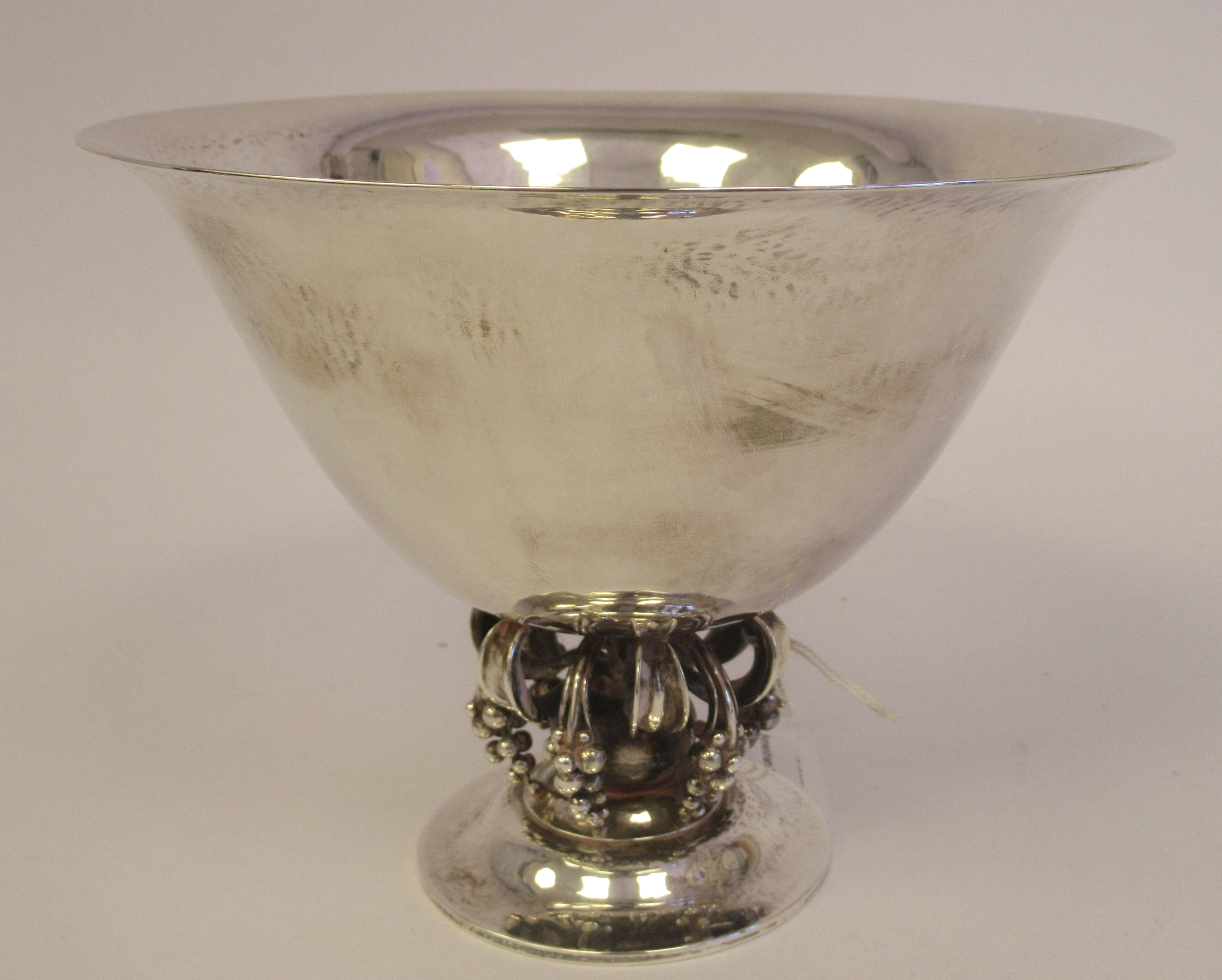A 1950s Georg Jensen spot-hammered silver bowl, no.775, having wide, flared sides, elevated on short